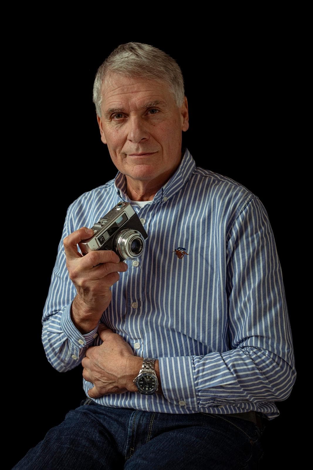 Michael Boon met camera tegen een donkere achtergrond